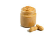 Peanut butter in a glass jar with peanuts isolated on white background.  A traditional product of American cuisine.