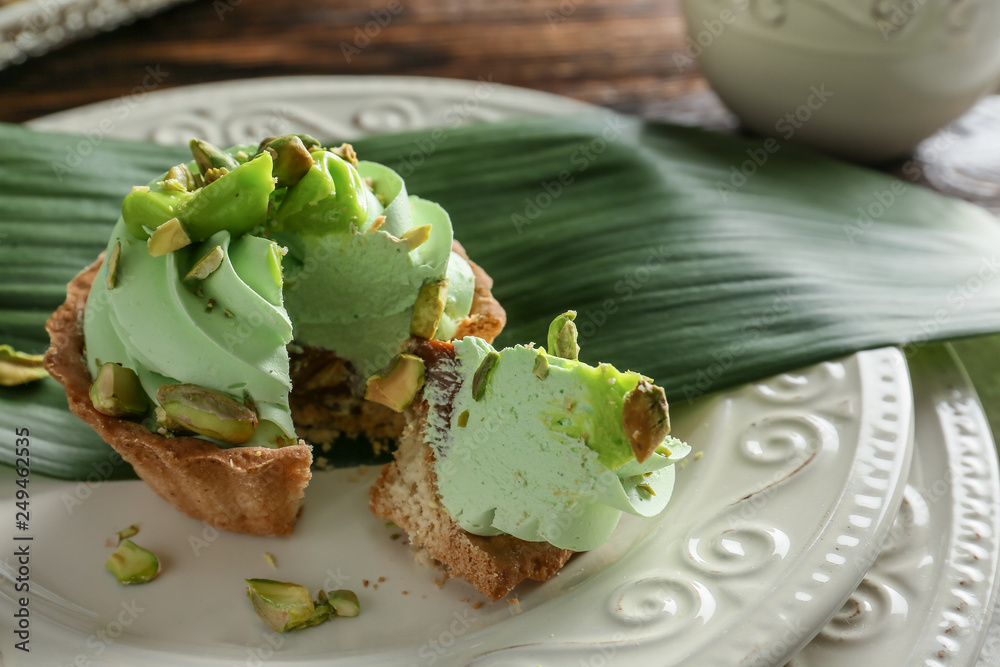 Tasty pistachio tartlet on plate, closeup