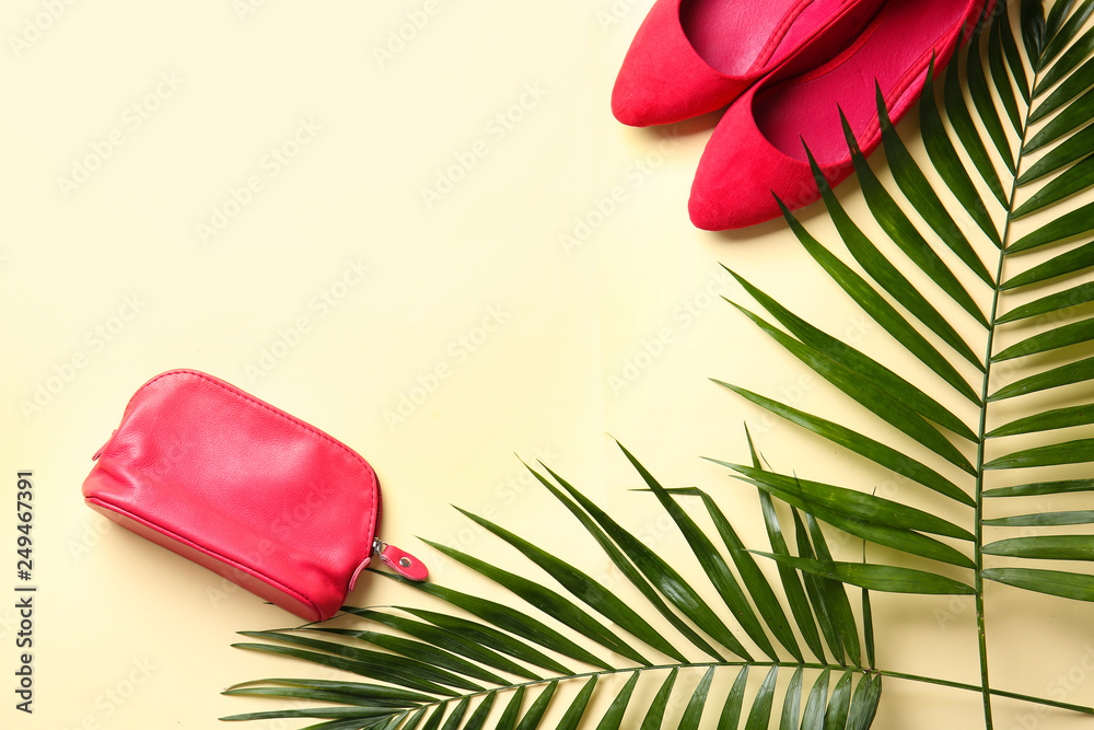 Flat lay composition with female accessories and tropical leaves on light background