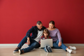 Sticker - Happy family with laptop sitting on floor in their new flat