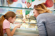 Mother and daughter chooses ice cream in confectionery