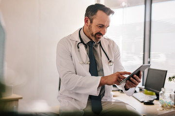 Doctor using digital tablet at his clinic