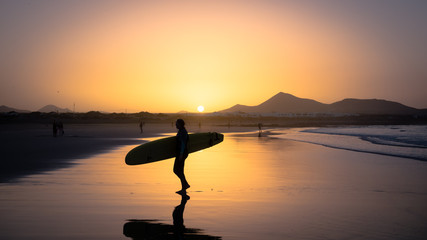 Silhouette of a Surfer on Famara beach at sunset