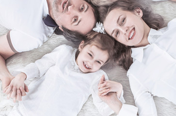 concept of family happiness: happy family relaxing on the carpet on Sunday