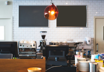 Counter top at a bright cafe with empty blackboards on the wall for copy space