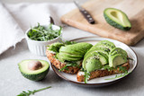Fototapeta  - healthy breakfast with avocado and Delicious wholewheat toast. sliced avocado on toast bread with spices. Mexican cuisine
