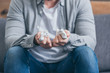 © LIGHTFIELD STUDIOS - cropped view of man in grey shirt and blue pants sitting on couch with baby shoes, grieving disorder concept