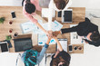 © InfiniteFlow - Businessmen and businesswomen joining hands in group meeting at multicultural office room showing teamwork, support and unity in business. Diversity workplace and corporate people working concept.