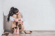 © LIGHTFIELD STUDIOS - upset woman sitting on floor and holding photo near white wall at home, grieving disorder concept