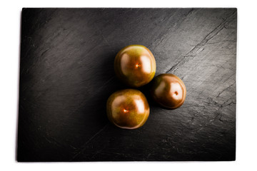 group of dark red kumato tomatoes