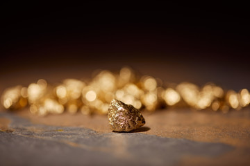 selective focus of golden stones on brown marble and blurred background