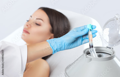 Fotomural The blood tube is removed from the medical centrifuge for plasma lifting