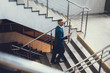 © Yakobchuk Olena - Man holding cellular in hand and walking on stairs