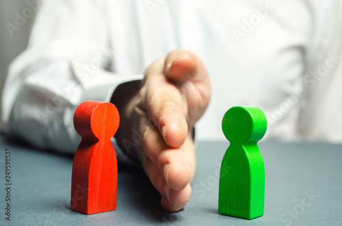Fotografía The person divides with the palm the red and green figures of people