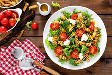 Italian Pasta Salad With Wholegrain Fusilli, Fresh Tomato, Cheese, Lettuce And Broccoli On Wooden Rustic Background. Mediterranean Cuisine. Cooking Lunch. Healthy Diet Food. Top View