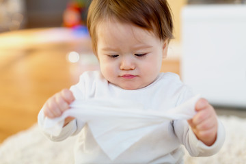 Little toddler boy holding a tissue to his face