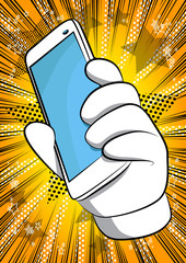 Wall Mural - Vector cartoon hand holding a cell phone. Illustrated hand with smart phone on comic book background.