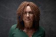 © amixstudio - Portrait of an authentic adult woman with afro curls against a black wall in the studio. Unusual stylish woman with red hair