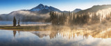 Fototapeta Fototapety góry  - South Sister and Broken Top reflect over the calm waters of Sparks Lake at sunrise in the Cascades Range in Central Oregon, USA in an early morning light. Morning mist rises from lake into trees. 