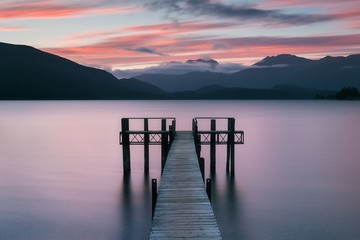 Romantic wharf on Te Anau on South Island of New Zealand Beautiful pier on sunrise. Lake Te Anau is the largest lake in the South Island and within New Zealand second only to Lake Taupo.