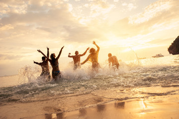 Poster - Happy friends runs or having fun at idyllic sunset sea