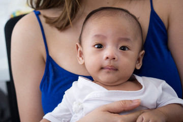 Smiling baby in her mother's care