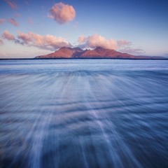 Wall Mural - Island in the horizon. Beautiful, dreamy sky and the sea in Scotland. Waves crossing on shoreline with moody dramatic sky on the Isle of Skye, Scotland, UK Isles in north atlantic ocean travel concept