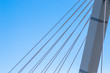 © Artem - Cable-stayed bridge close-up against the blue sky. White bridge structure on a blue background. Neutral minimalistic background.