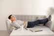 © makistock - Asian guy daydreaming and rest at home. Asian man relaxed and sleep on sofa indoor. Handsome male model.