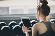 Fitness Woman Using Tablet After Exercise In Gym