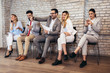 © Mediteraneo - Business people waiting for job interview. They use their phones while waiting