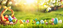Easter Eggs In A Basket On Green Grass And Sunny Spring Background