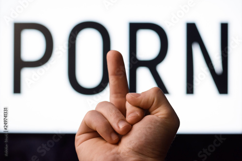 Man shows middle finger to a screen with inscription PORN ...