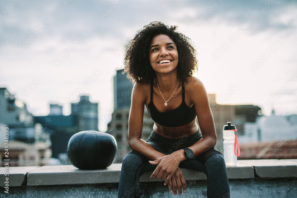 Smiling woman athlete taking a break during workout - obrazy, fototapety, plakaty 