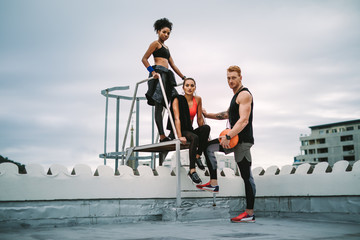 Wall Mural - Group of athletes standing on rooftop after workout