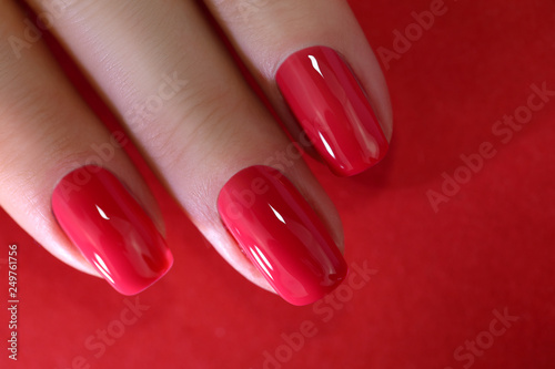 Red Finger nail point isolated red background with nail polish Fototapet