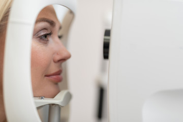 Poster - Beautiful woman having eye examination in clinic