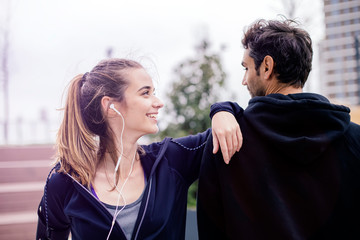 Male coach helping young woman exercising at outdoors