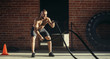 © alfa27 - Athletic young man with battle rope doing exercise in functional training fitness gym. Rope helps engage all muscle groups at the same time, while ensuring freedom of movement.