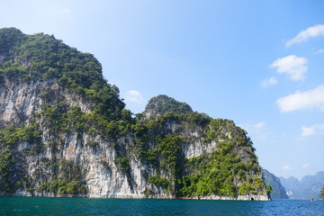 photo picture of a beautiful sea and ocean view with a natural background of rocks, forests and mountains