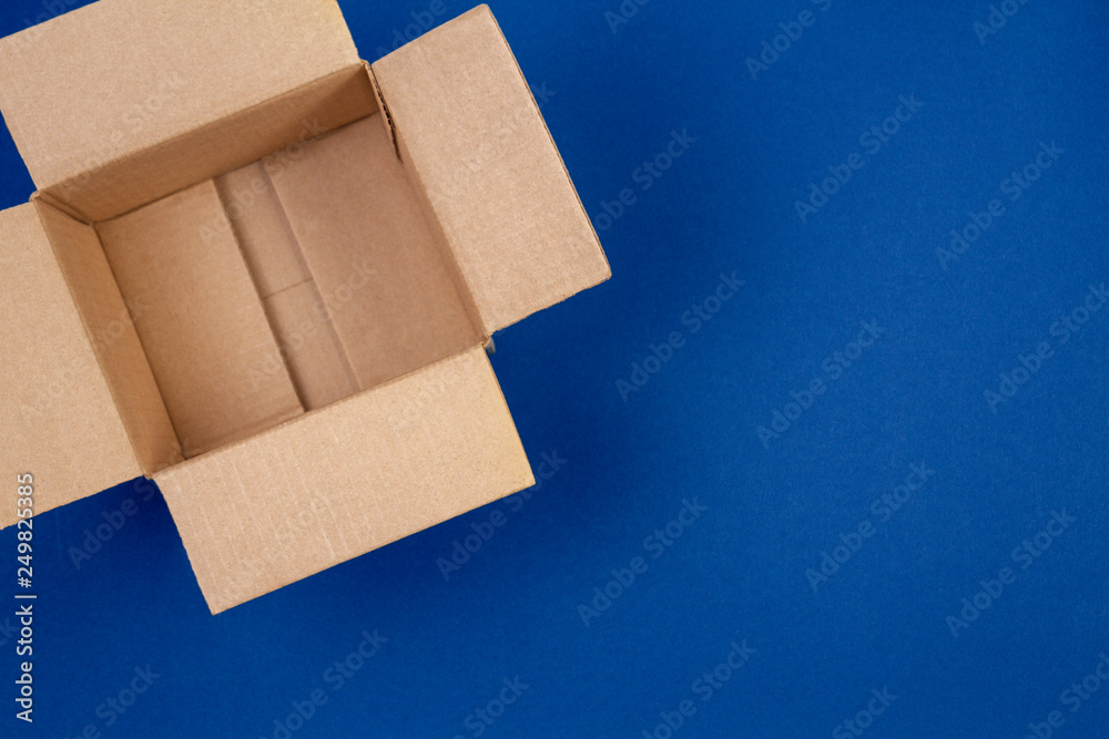 Open empty cardboard boxes on blue background - obrazy, fototapety, plakaty 