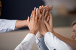 © fizkes - Close up of diverse people hands giving high five