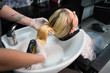 © strigana - Beauty concept - Professional hairdresser applying shampoo, washes color paint off and massaging hair of a customer. Woman having her hair washed in a hairdressing beauty salon