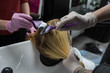 © strigana - Professional hairdresser putting color mask dyeing hair of woman in beauty salon