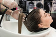 © strigana - Beauty concept - Professional hairdresser applying shampoo, washes color paint off and massaging hair of a customer. Woman having her hair washed in a hairdressing beauty salon