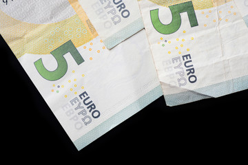 Five euro banknotes on a dark background close up