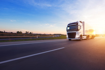 Loaded European truck on motorway in sunset