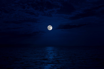 Wall Mural - Full moon rising over sea at night with copy space. big full moon reflecting in a sea. Azerbaijan