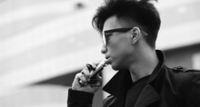 Black White Photo Of Asian Young Man Outdoors Posing
