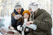 © Seventyfour - Portrait of happy family drinking hot tea in winter forest, copy space